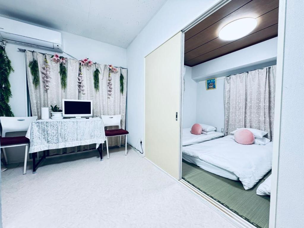 a room with a bed and a desk and a mirror at Ikebukuro-hostel池袋中川301&501-TS0038 in Tokyo