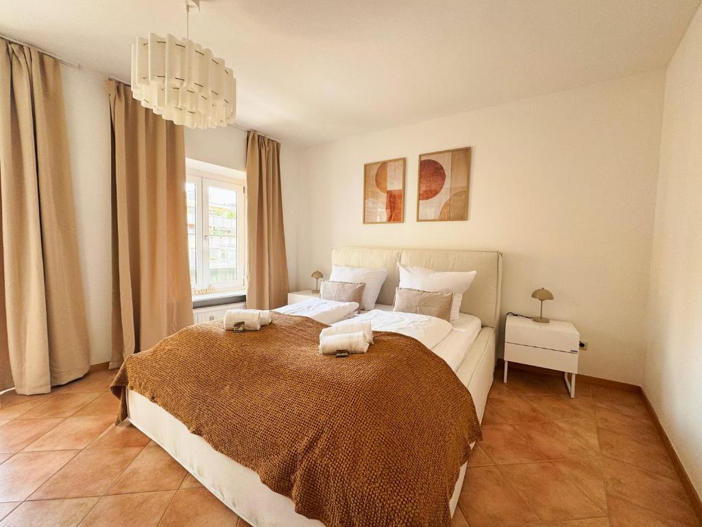 a bedroom with a large bed with two towels on it at ma suite - city sol apartment - centrum - private parking in Augsburg
