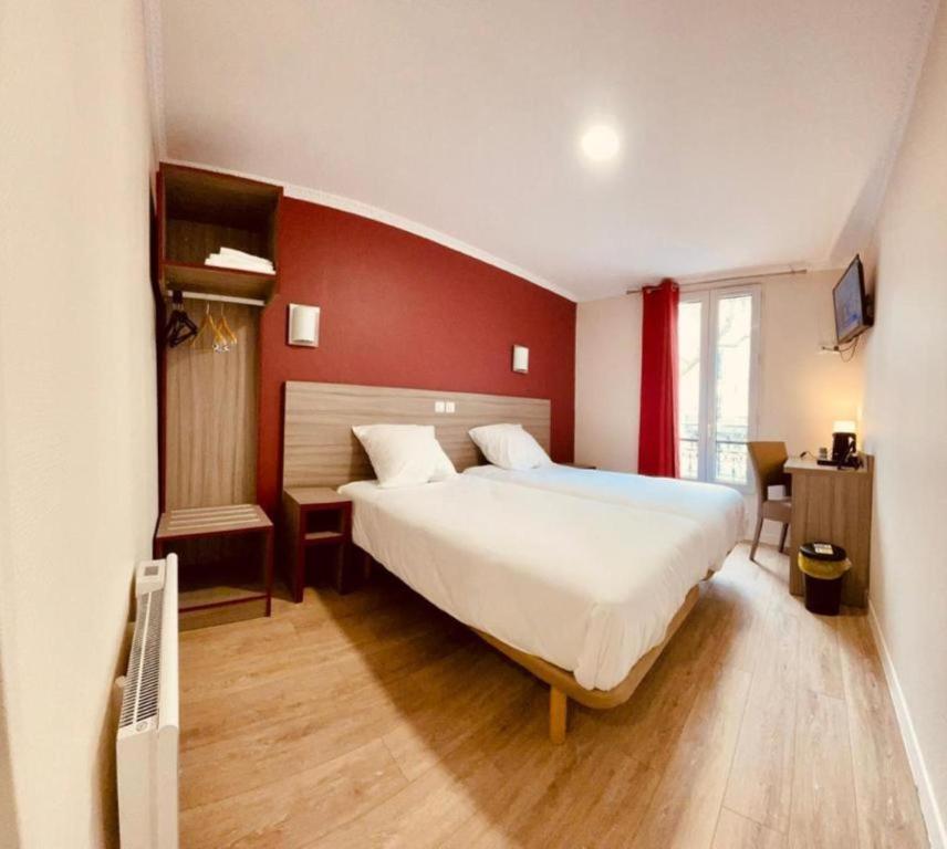 a bedroom with a large bed and a red wall at Hipotel Paris Gambetta République in Paris