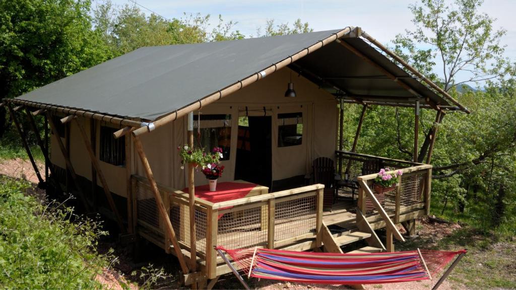 a cabin with a black roof with two chairs in front at Lodge Holidays - Casa Tartufo in Radicosa
