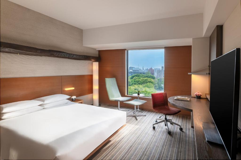 a hotel room with a bed and a desk and a window at Hyatt Regency Tokyo in Tokyo