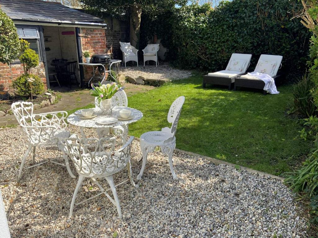 a patio with a table and chairs and a couch at Victorian Retreat - A Serene Sanctuary in Broadstairs