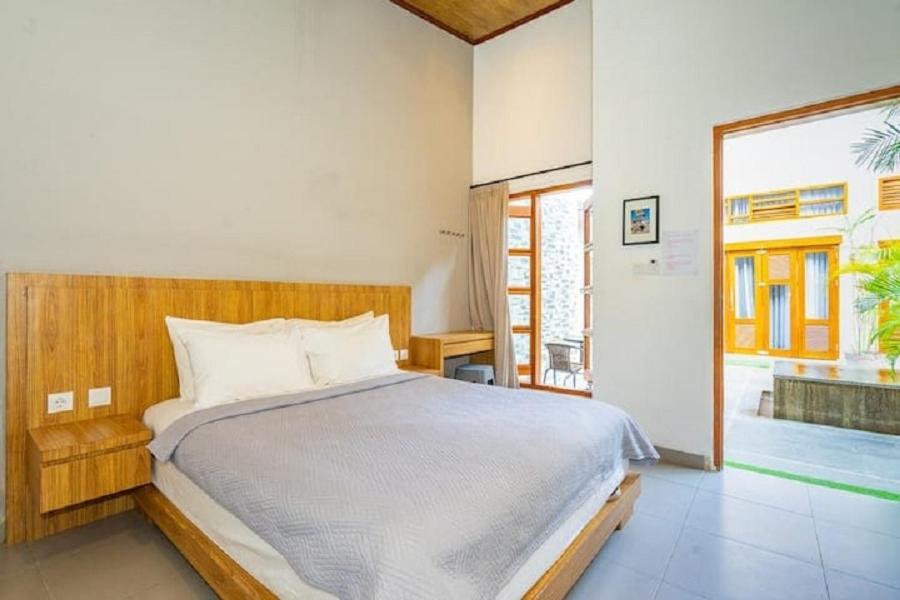 a bedroom with a bed and a large window at The Tanjung Bidadari Seminyak in Seminyak