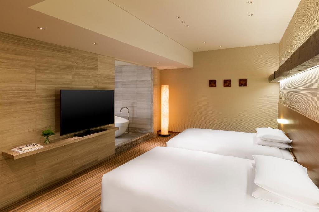a hotel room with a bed and a flat screen tv at Hyatt Regency Tokyo in Tokyo