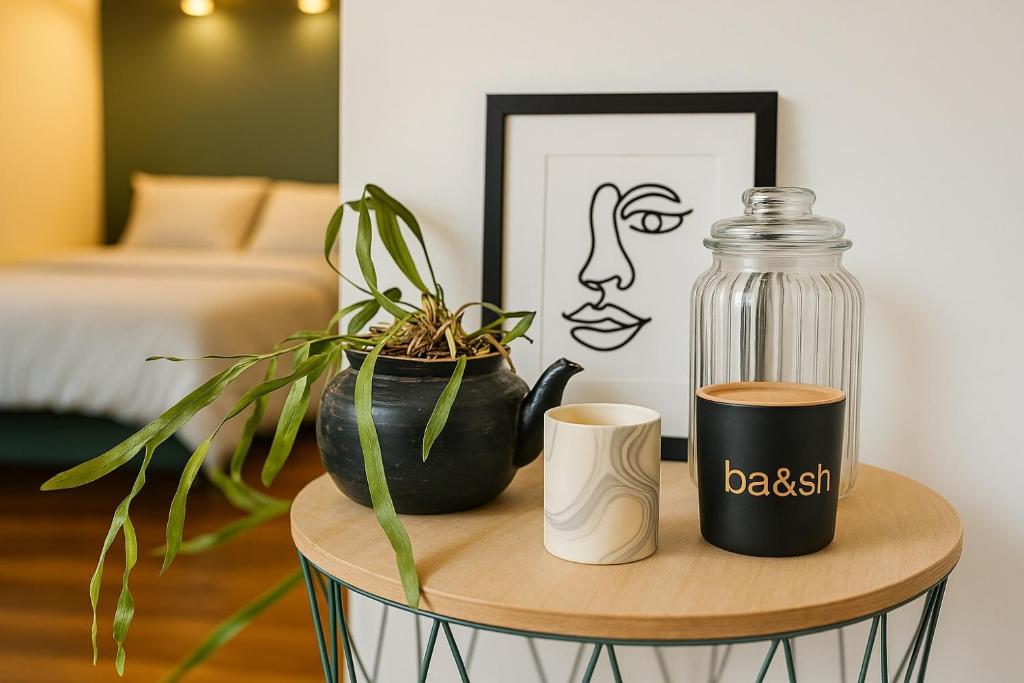 une table avec un bocal en verre et deux plantes dessus dans l'établissement Charmant Studio Montmartre dernier étage calme, à Paris