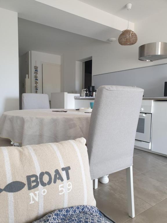 - un salon avec une table et une chaise avec un canapé dans l'établissement Nice apartment with garden, à Agde