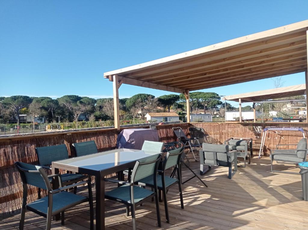 a patio with tables and chairs on a deck at Douce Provence - Provence Cote d'Azur in Vidauban