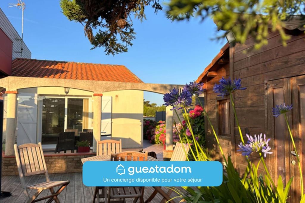 a home with a patio with chairs and flowers at La Tara - Vue mer - Parking - Terrasse in La Plaine-sur-Mer