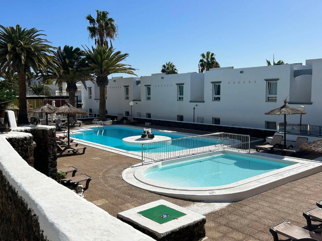 a swimming pool in front of a building at 42 Guacimeta Club in Los Pocillos