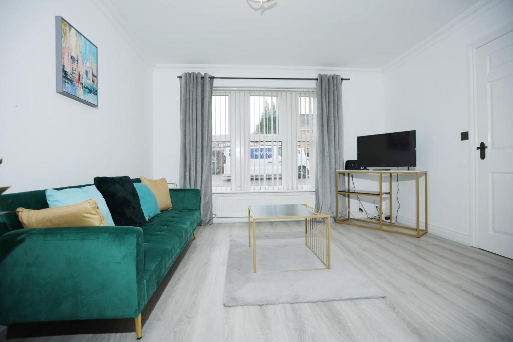 a living room with a green couch and a tv at Milestone House By N And N Stays, Contractor Friendly, 6 Bed house, Sleeps 10, Private Parking, WIFI in Cardiff