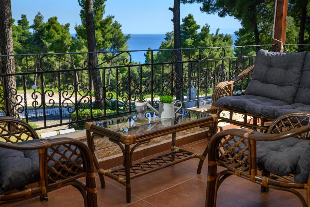 a patio with two chairs and a table on a balcony at Sani Villa Elmira in Sani Beach