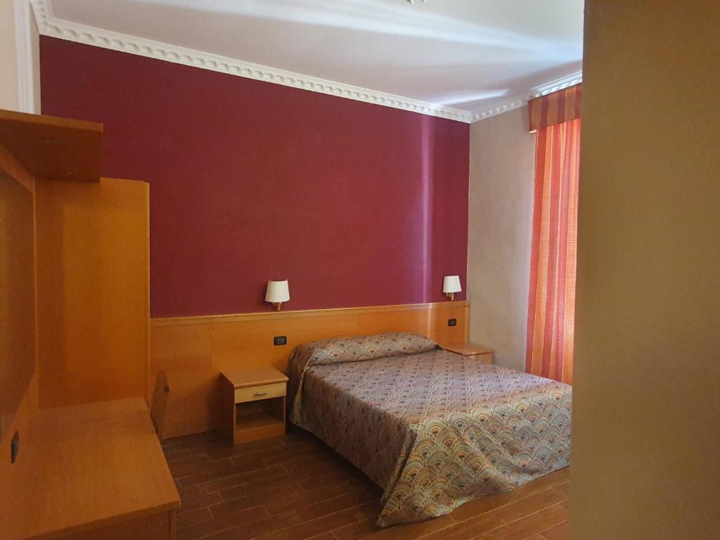 a bedroom with a bed and a red wall at Beauty Rooms in Rome