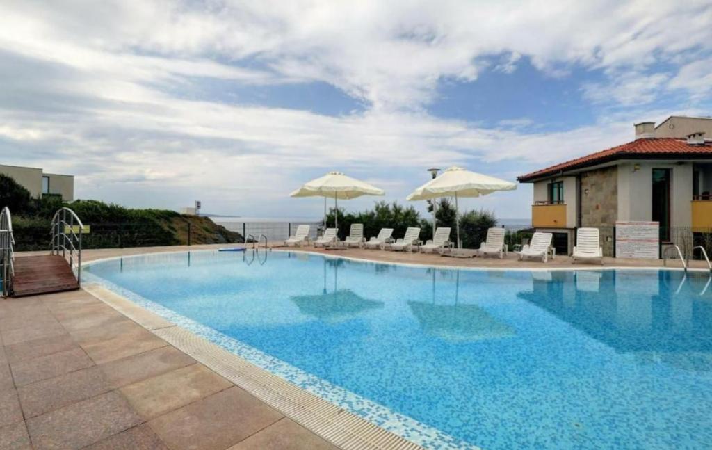 a large swimming pool with chairs and umbrellas at Appart complex - Egrek 3 in Lozenets