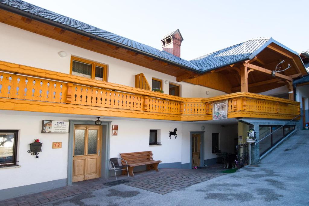 a building with a wooden balcony and a wooden bench at Rooms&Apartments Pazlar in Bled