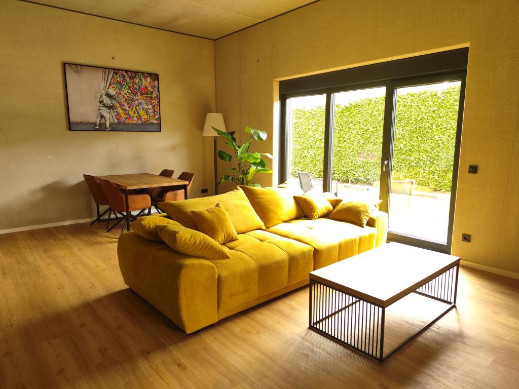 a living room with a yellow couch and a table at Tiny Loft Hunsrück in Sohren