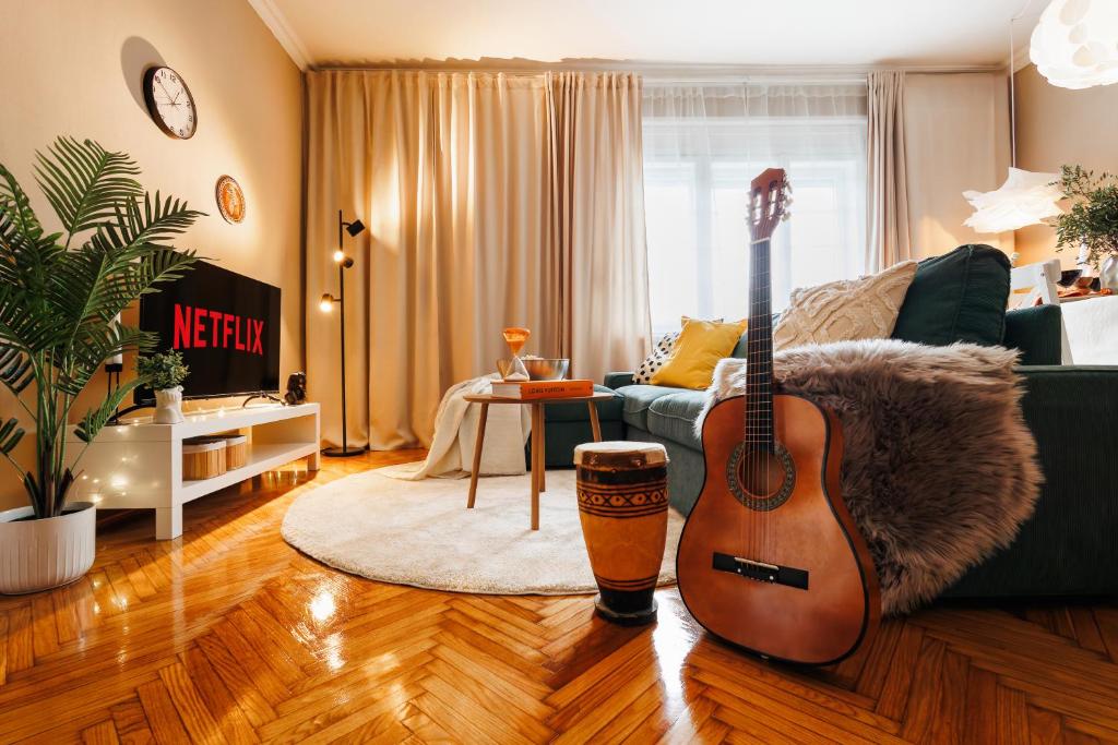 a living room with a guitar sitting on the floor at Harmonic Nest 3min to Republic Square Renovated in Belgrade