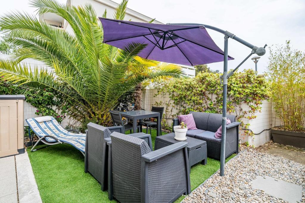 une terrasse avec un parasol violet, des chaises et une table dans l'établissement soleil d azur, à La Ciotat