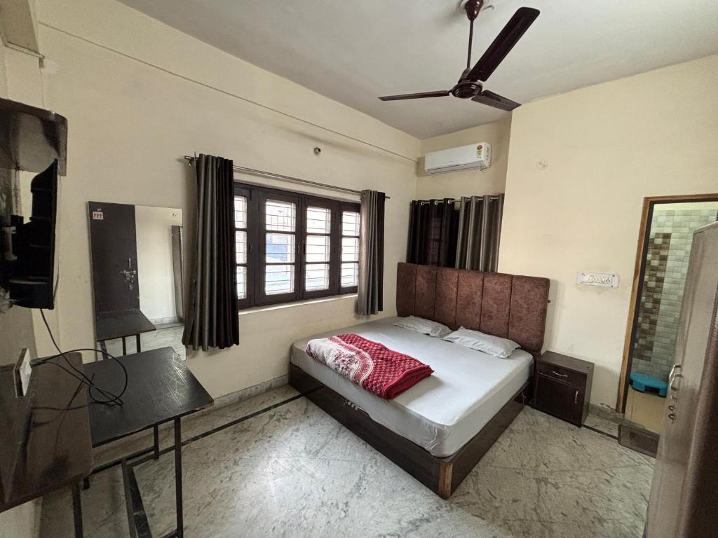 デヘラードゥーンにあるShree Ji Home Stay Peaceful & Comfortable Rooms in Dehradunのベッドと天井扇風機のある寝室