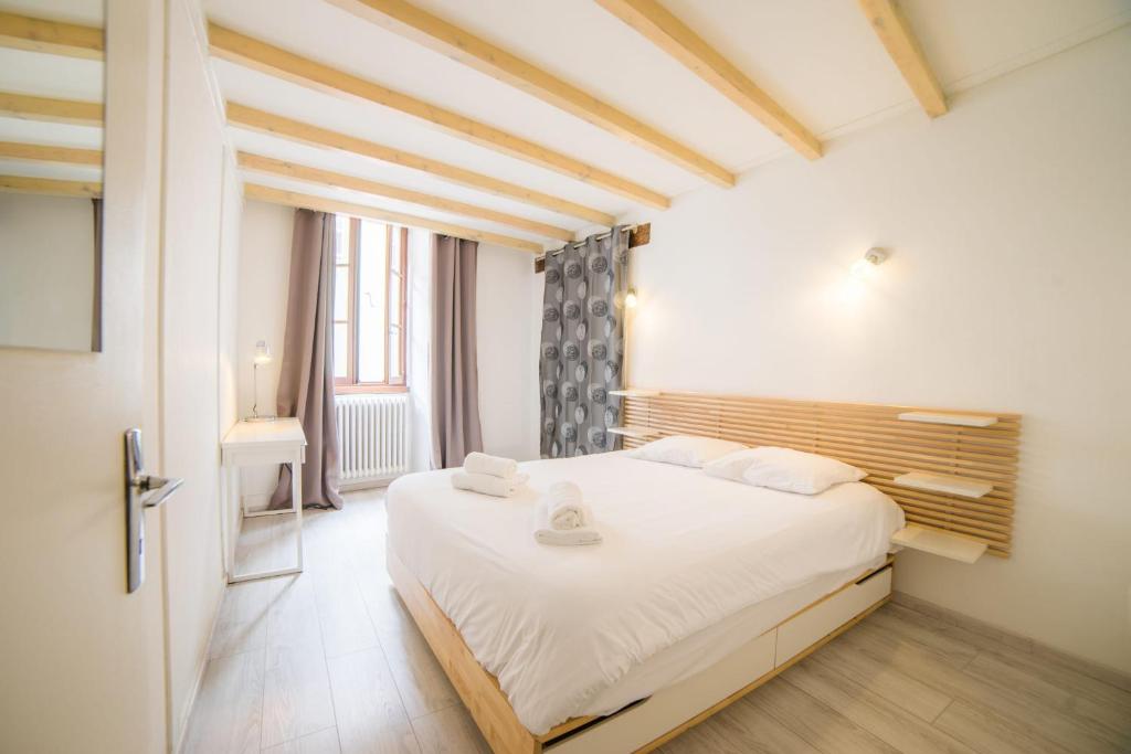 une chambre avec un grand lit blanc dans une pièce dans l'établissement Le Parmelan - apartment for 2 people in the heart of the old town, à Annecy