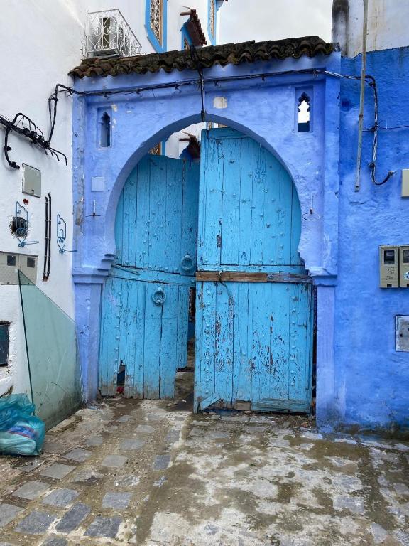 a blue building with two blue doors at Casa bohemia cerca del mar in La Marina