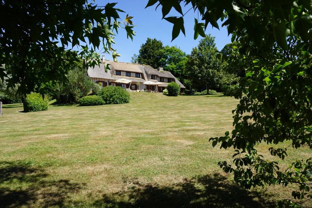 een grote tuin met een huis op de achtergrond bij La Moutinière, luxury cottage with pool in Manerbe