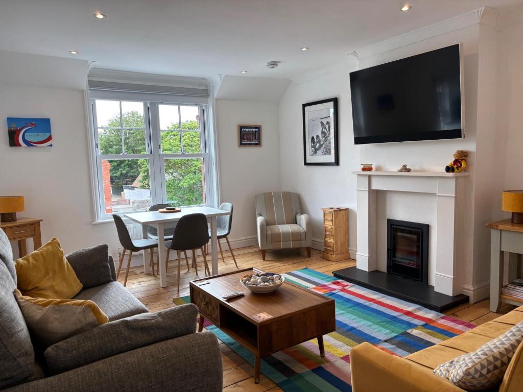 a living room with a couch and a table at Seafront Sheringham 1 bed Apt sleeps 4 - 1xdog in Sheringham