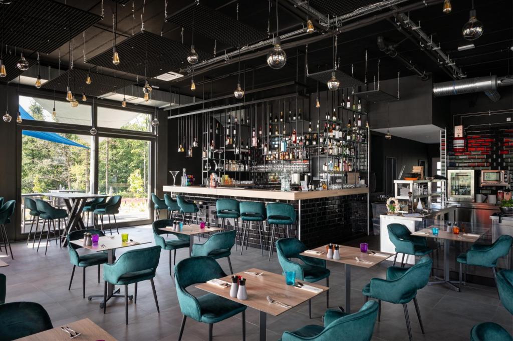 restauracja ze stołami i krzesłami oraz bar w obiekcie Hotel Ózon & Luxury Villas w mieście Mátraháza