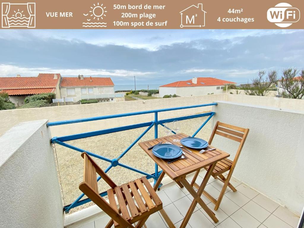 une table et des chaises sur un balcon avec vue sur la plage dans l'établissement Appartement Rénové Face à la Mer, 200m Plage de la Sauzaie, Balcons, Wifi, Parking à Proximité - FR-1-231-224, à Bretignolles-sur-Mer