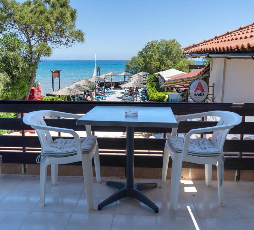 a table and two chairs on a balcony with the beach at Oasis Beachfront Studios & Apartments, by ZanteWize in Alikanas