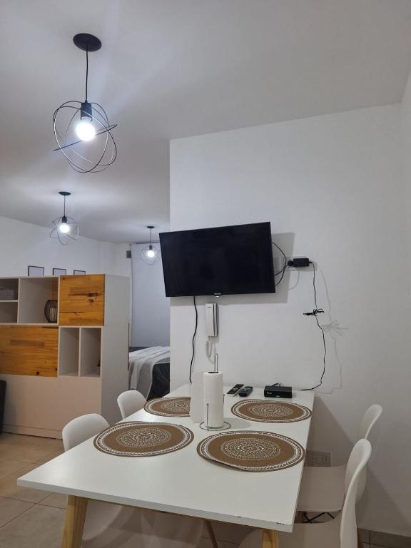 a white dining room table with a tv on the wall at Amoblado Carlos I in Río Cuarto