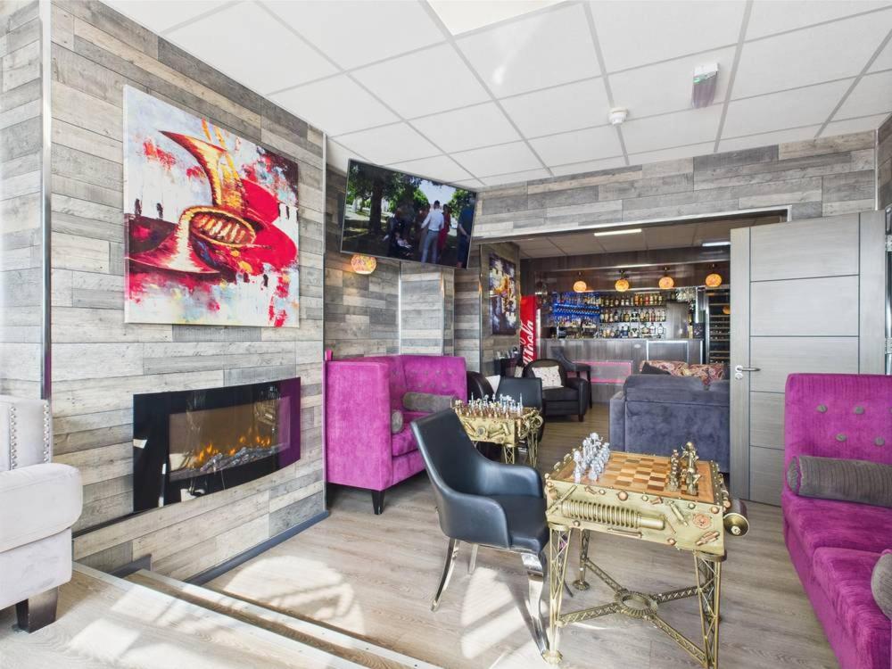 a living room with purple furniture and a fireplace at Kings Boutique Hotel in Blackpool