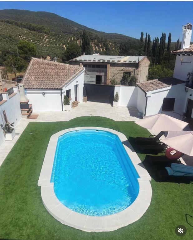 a swimming pool in the yard of a house at Nuestro Refugio Rural in Cortijos Nuevos