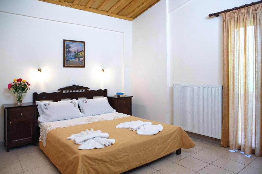 a bedroom with a bed with white towels on it at Aposperitis Village in Theodhóra