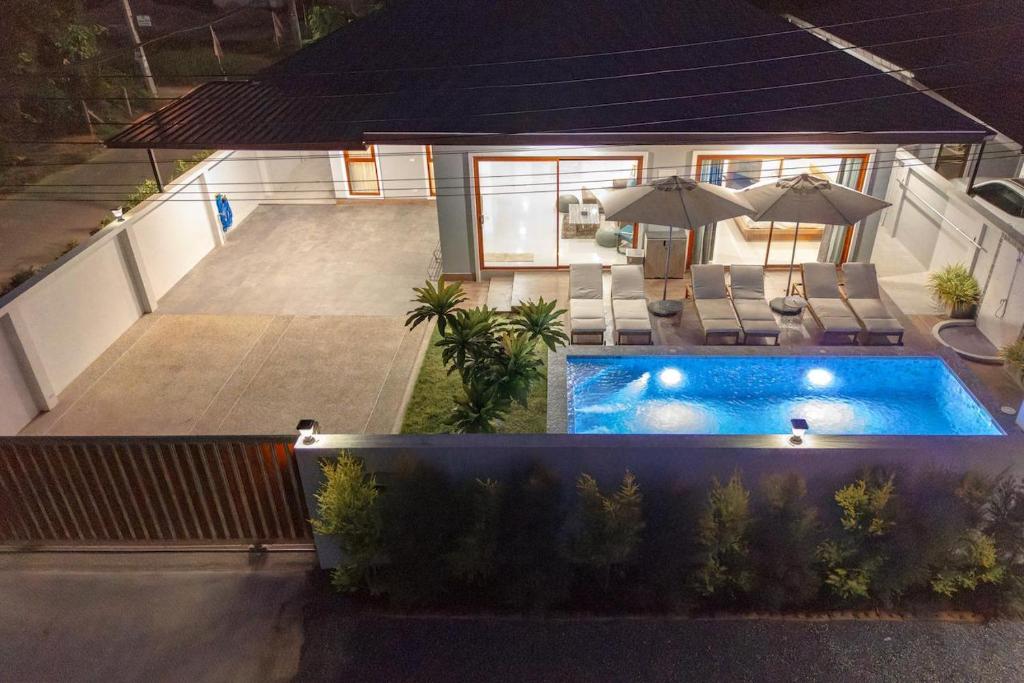 eine Draufsicht auf einen Swimmingpool mit Sonnenschirmen in der Unterkunft New Pakbia Private Pool Villa 3 Bed Ao Nang Krabi in Ban Chong Phli