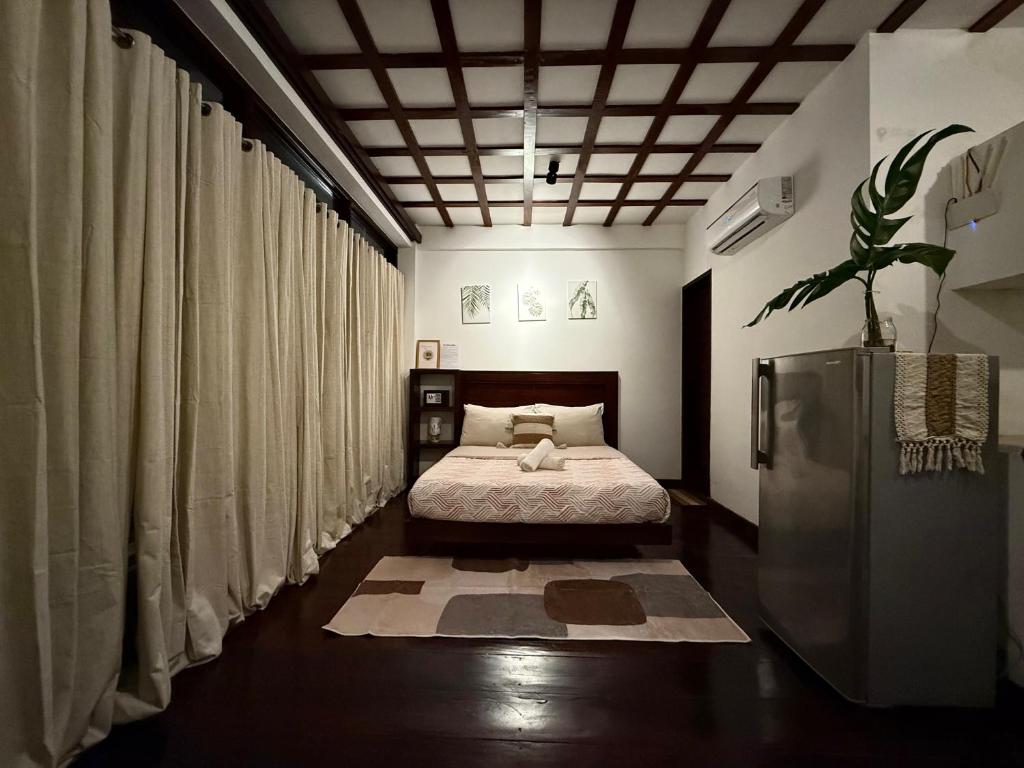 a bedroom with a bed in a room with curtains at Bayay ni Mamang Siargao - Ground Level in General Luna