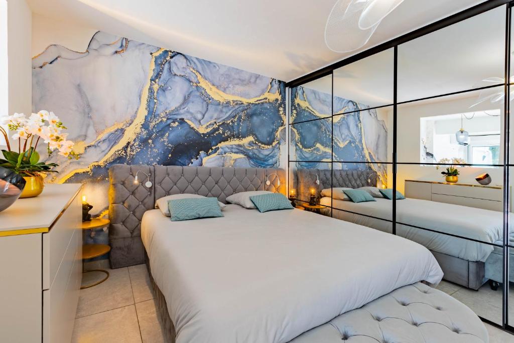 - 2 lits dans une chambre avec une fresque murale dans l'établissement Villa Luxe Port Nature 2, au Cap d'Agde