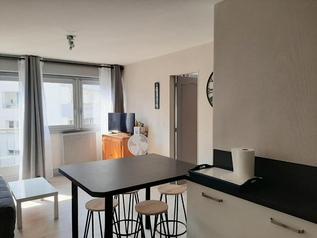 une cuisine avec une table et des tabourets dans une pièce dans l'établissement Appartement Confortable en Plein Centre de Saint-Jean-de-Luz, à Deux Pas de la Plage et des Commerces - FR-1-239-586, à Saint-Jean-de-Luz