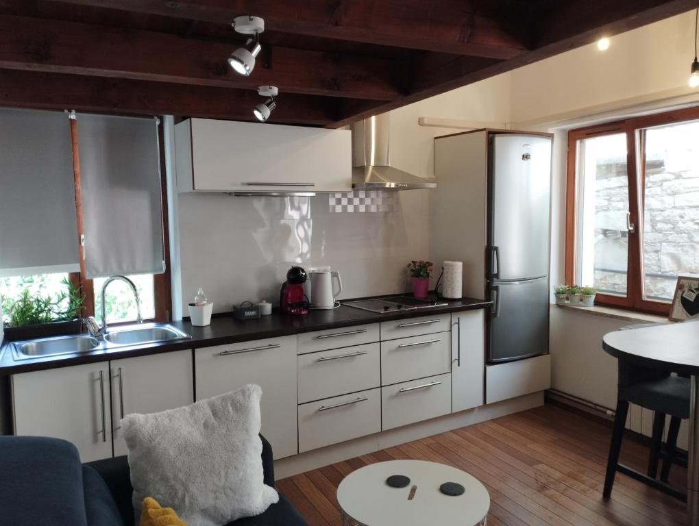 kuchnia z białymi szafkami i urządzeniami ze stali nierdzewnej w obiekcie Apartment Atlantis w Puli