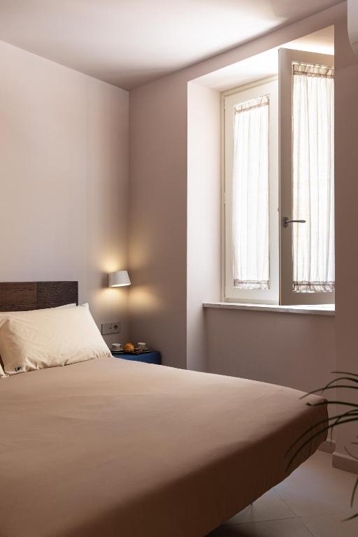 a bedroom with a bed and a window at Freshwater Pirates SUITES in Gaeta