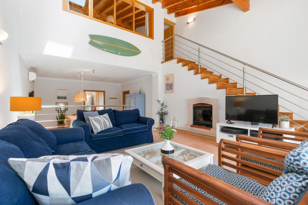 ein Wohnzimmer mit blauen Sofas und einem Fernseher in der Unterkunft Pita's House - Villa Sagres 2 in Sagres