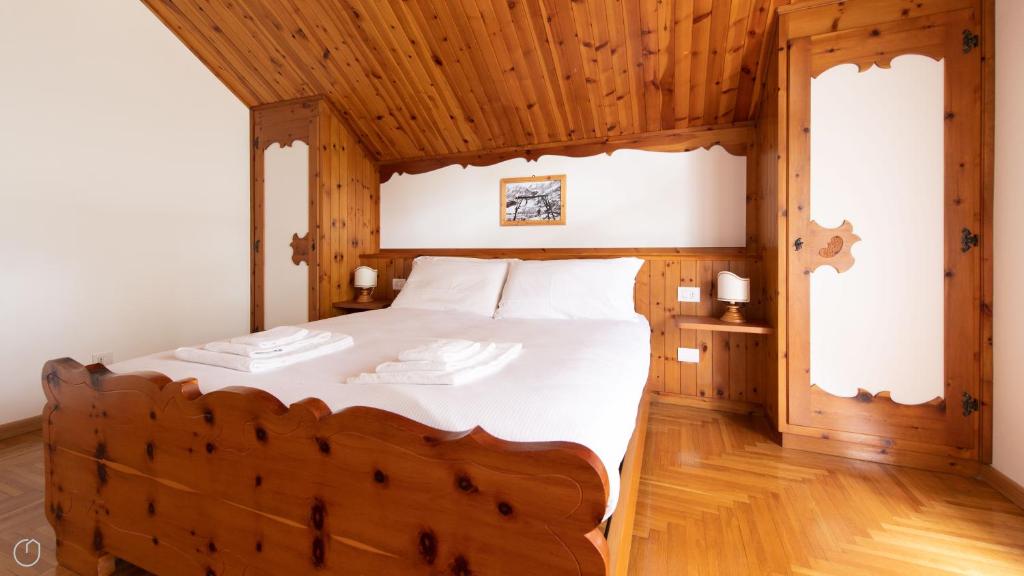 a bedroom with a large bed with wooden ceilings at Italianway - Besta 2 in Bormio