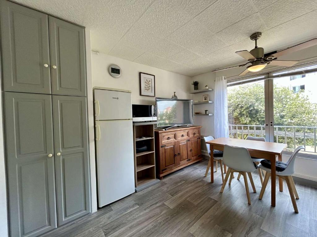 une cuisine avec une table et un réfrigérateur blanc dans l'établissement Studio Cap d'Agde CT077-043, au Cap d'Agde