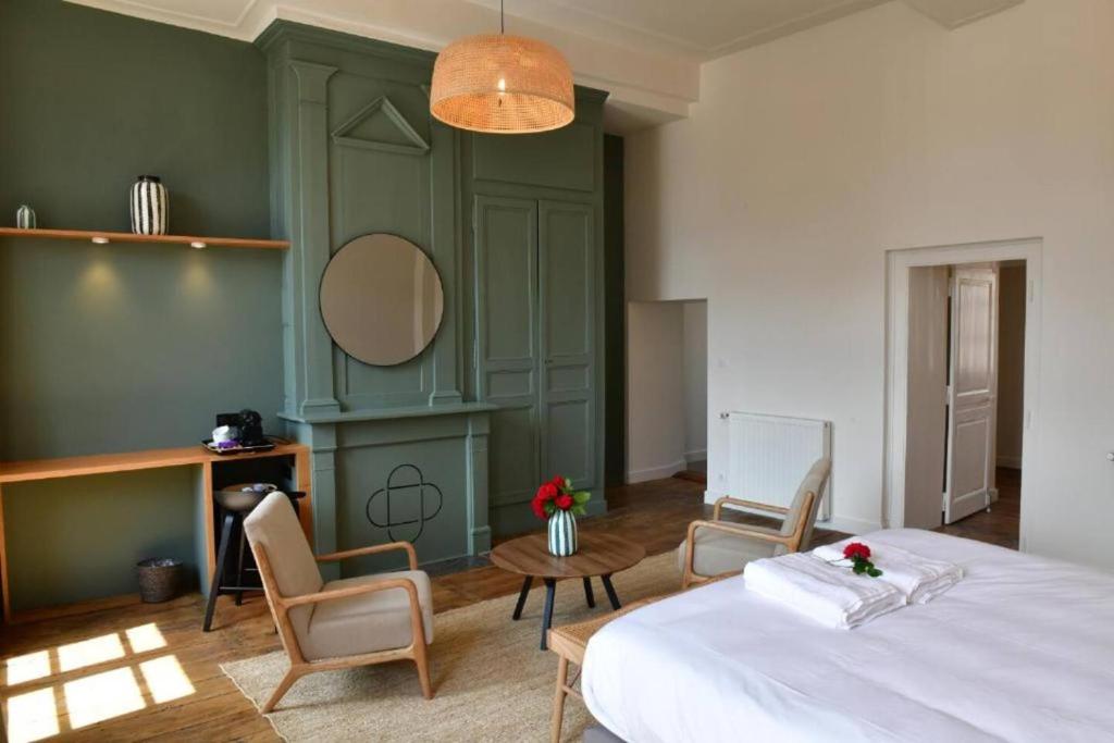 - une chambre avec un lit, des chaises et un miroir dans l'établissement Les Chambres du Cloître, la Confiseuse, à Limoges