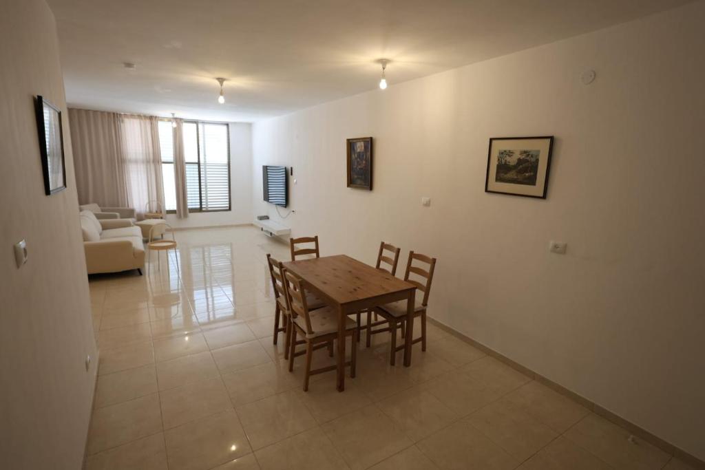 a dining room and living room with a table and chairs at Vacation rental in Netanya