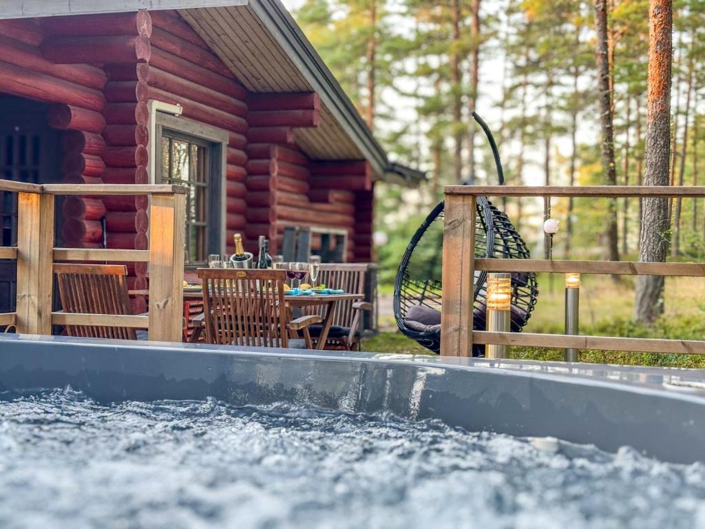 eine Blockhütte mit einem Pool davor in der Unterkunft Villa Pihlajanmarja is a Stunning Log Villa on a Waterfront Estate in Långstrand