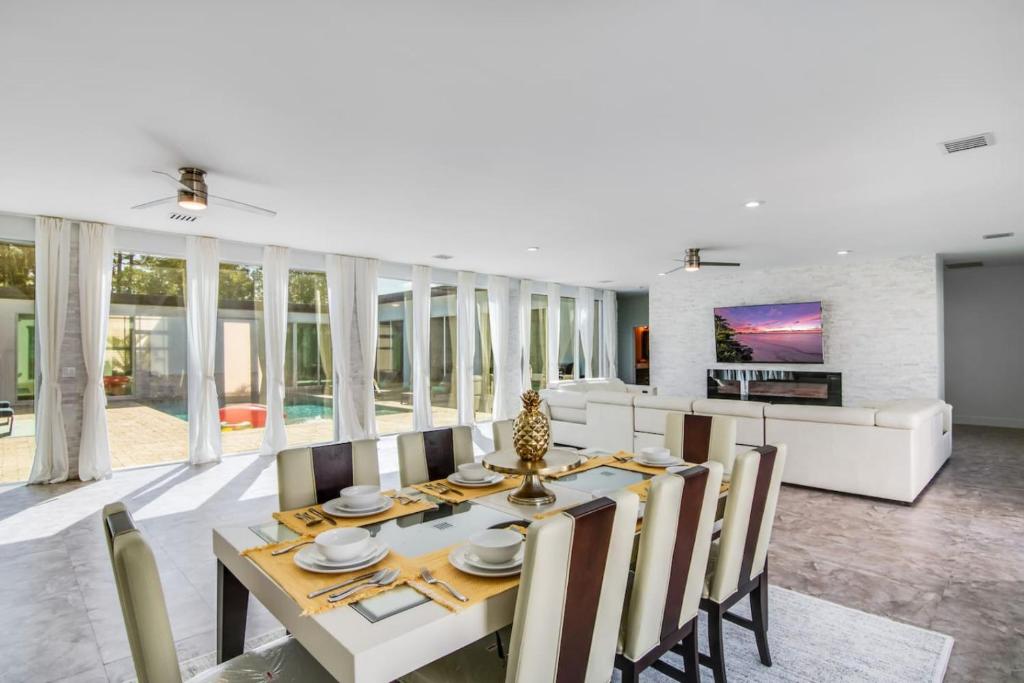 a dining room and living room with a table and chairs at Equestrian Stay, Heated Pool, Game Room, Fire Pit in Loxahatchee