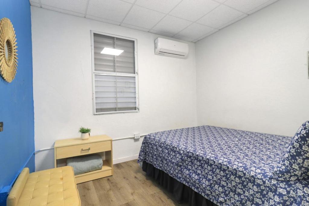 Un dormitorio con una cama y una silla y una ventana. en Explore Puerto Rico, en San Juan