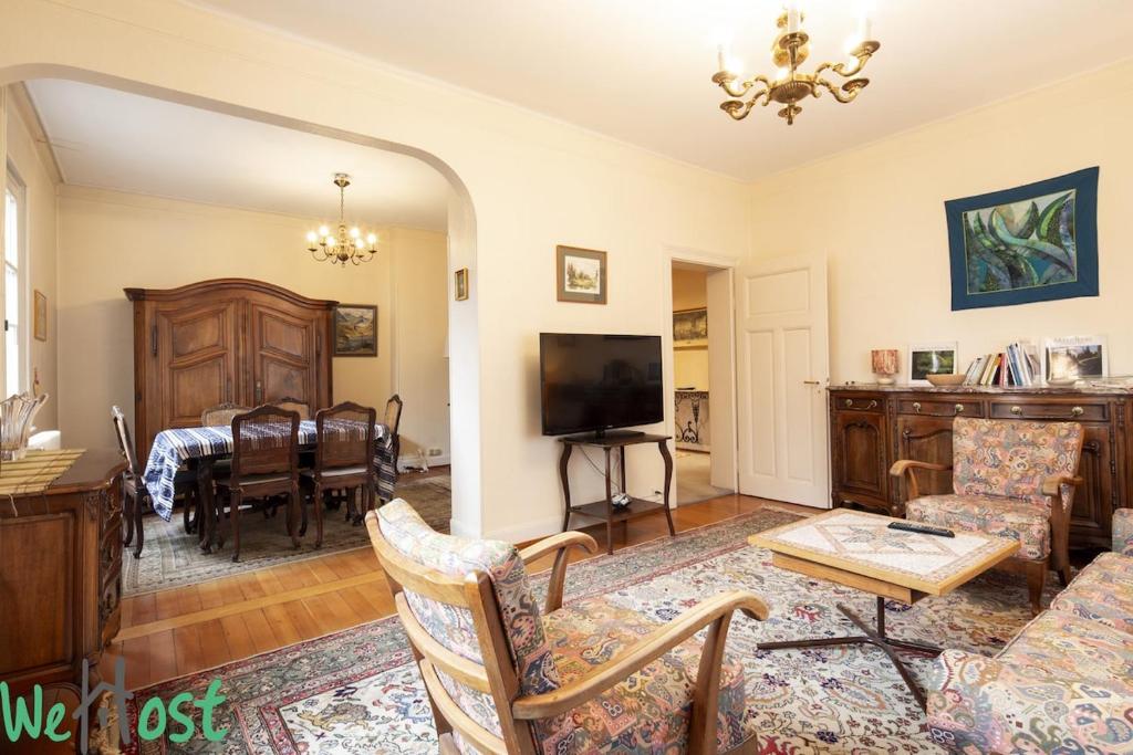 un salon avec un canapé et une salle à manger dans l'établissement Orangerie - Appartement 2 chambres et jardin partagé, à Strasbourg