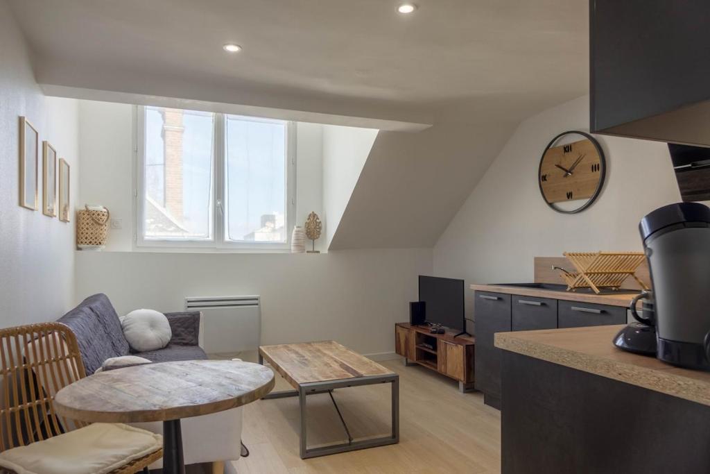 un salon avec un canapé et une table dans l'établissement Le Naturel, à Montargis