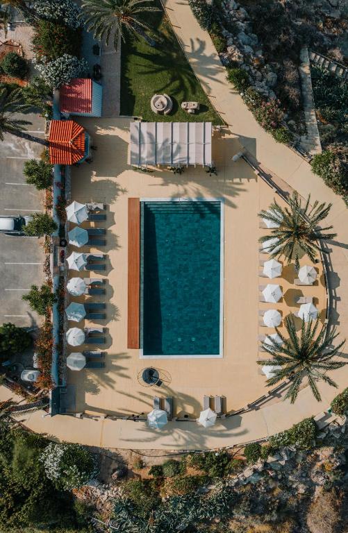 an overhead view of a swimming pool with umbrellas and chaises at Vrachia Beach Hotel & Suites - Adults Only in Paphos